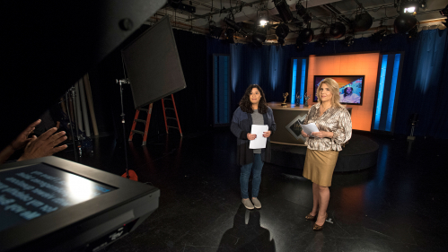 Grad student Alice Hernandez (SMLR'18) and host Ebby Antigua rehearse on set for taping