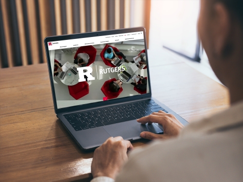 A person viewing the Rutgers website on a laptop